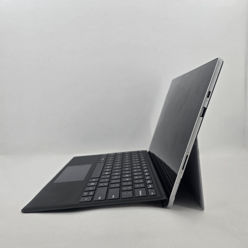 نمای کنار تبلت استوک مایکروسافت Surface Pro 5 با بدنه نقره‌ای از آلیاژ منیزیم-آلومینیوم، لبه‌های گرد، ضخامت 8.5 میلی‌متر، و کیک‌استند لولایی با قابلیت تنظیم زاویه تا 165 درجه.